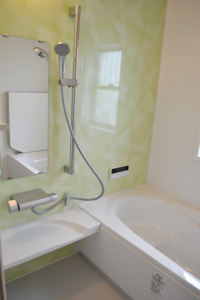 ミントグリーンの壁が爽やかな浴室